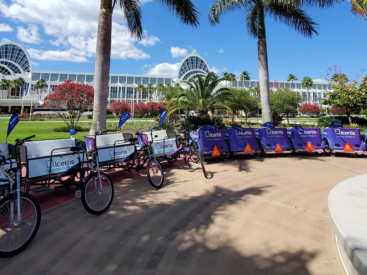 Icertis branded Kween Cab pedicab fleet outside the Orange County Convention Center in Orlando