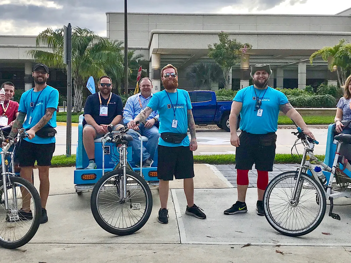Kween Cab drivers in client branded shirts lined up with their pedicabs