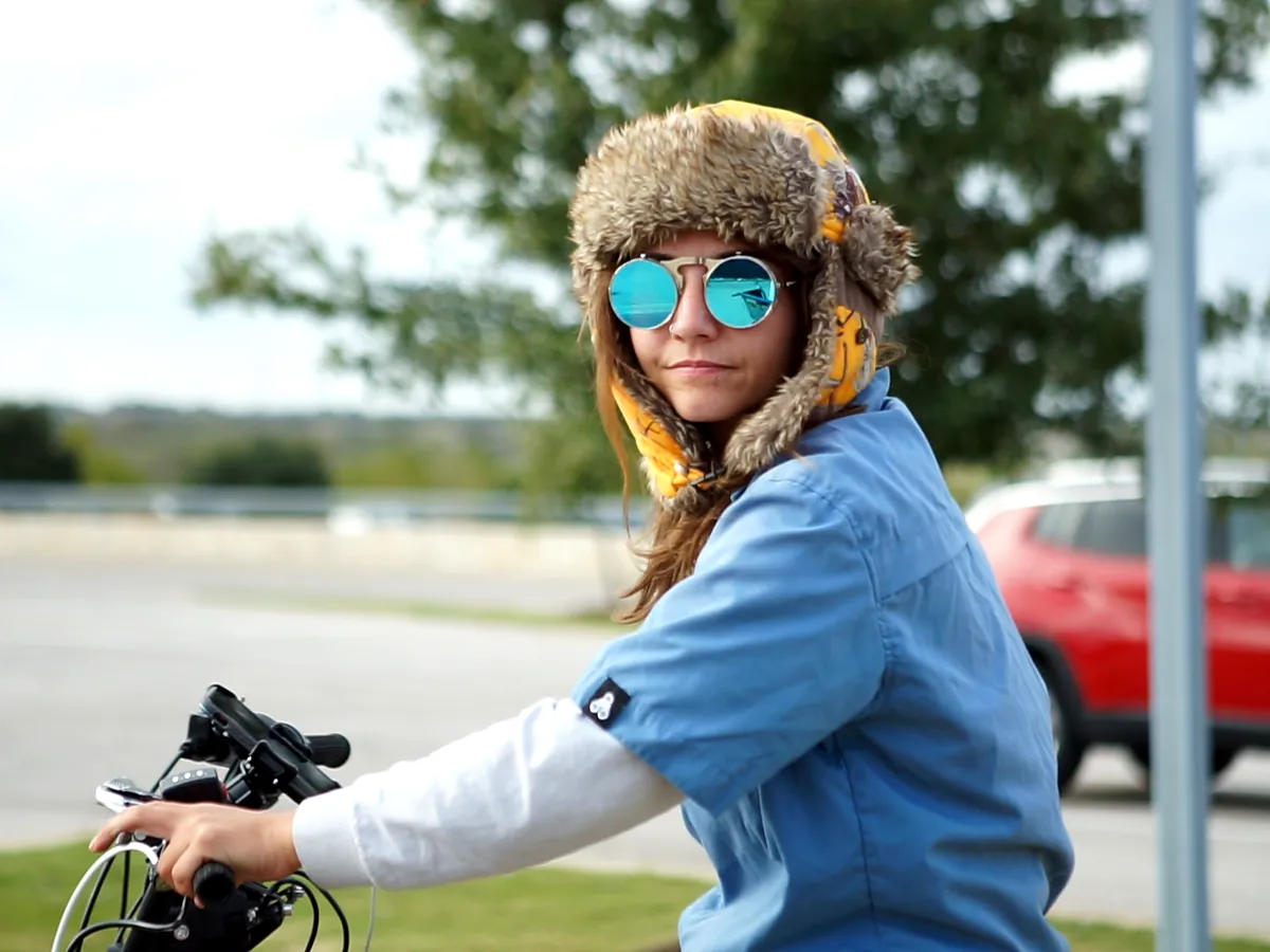 Smiling Kween Cab driver in a fur hat and mirrored sunglasses
