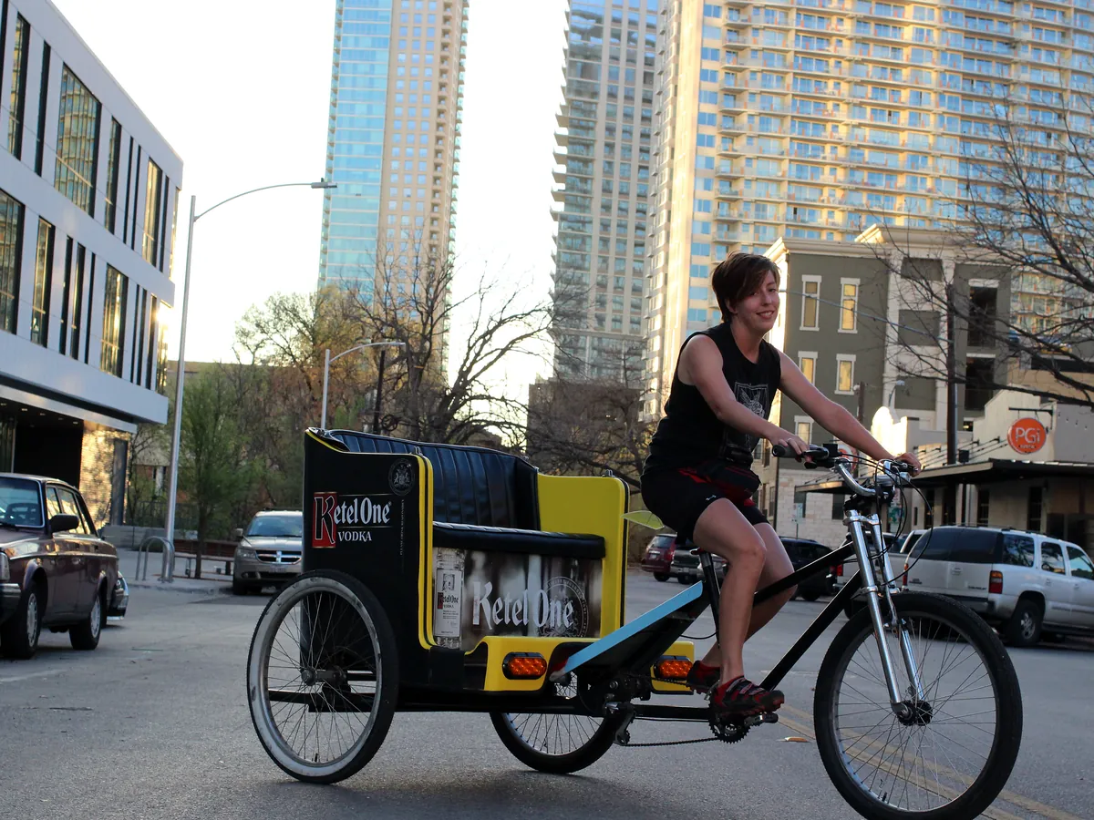 Ketel One branded Kween Cab pedicab with the downtown Austin skyline