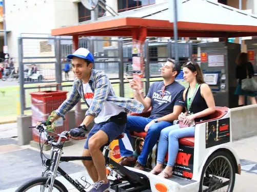 Riders in a branded pedicab downtown