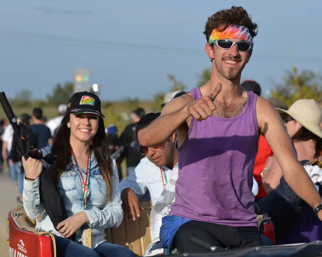 Excited riders in a Kween Cab pedicab at a race