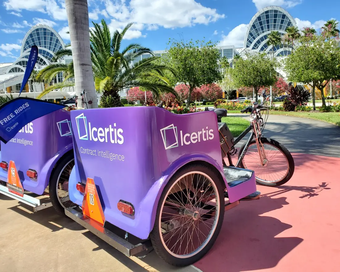 Close-up of Icertis Contract Intelligence pedicab panels with the convention center dome behind