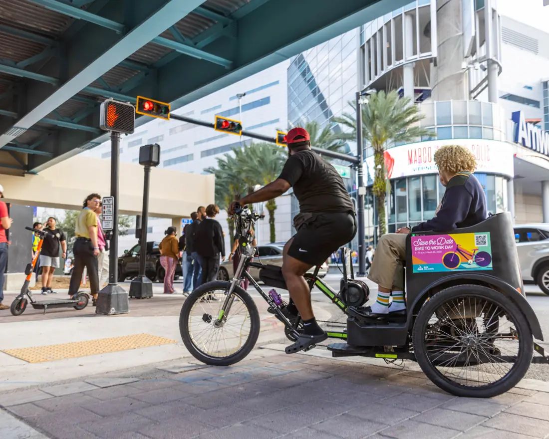 Convention attendee riding a branded pedicab downtown