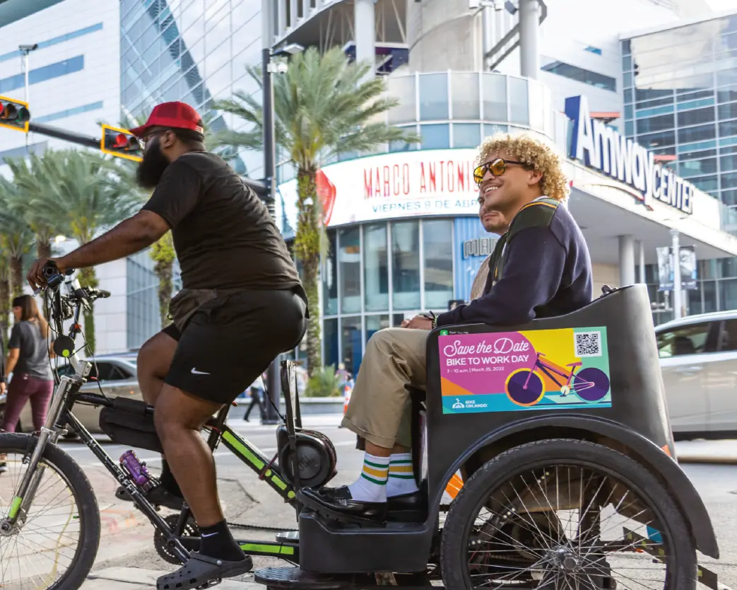 Convention attendee riding a branded pedicab