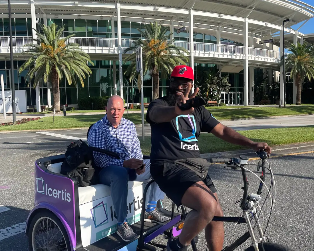 Driver in an Icertis shirt giving attendees a ride at the convention center