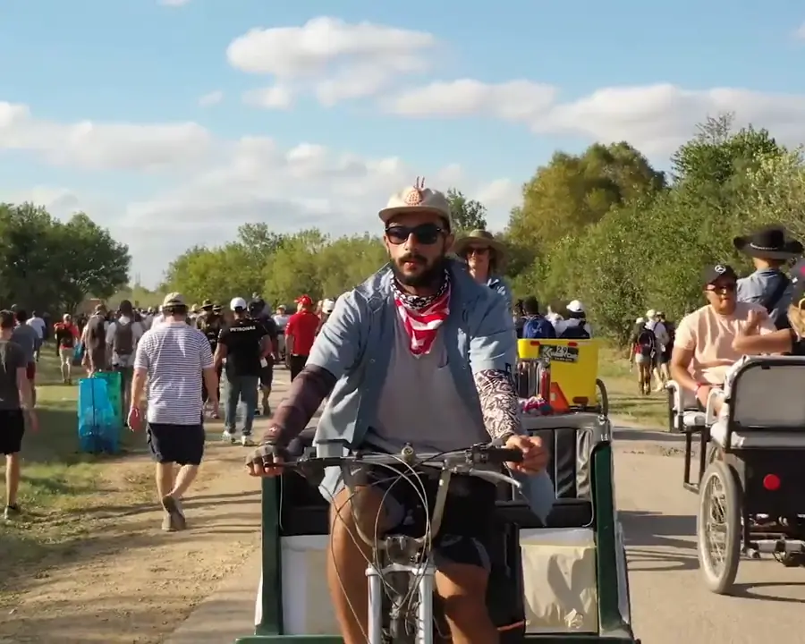 Kween Cab driver pedaling through a festival crowd