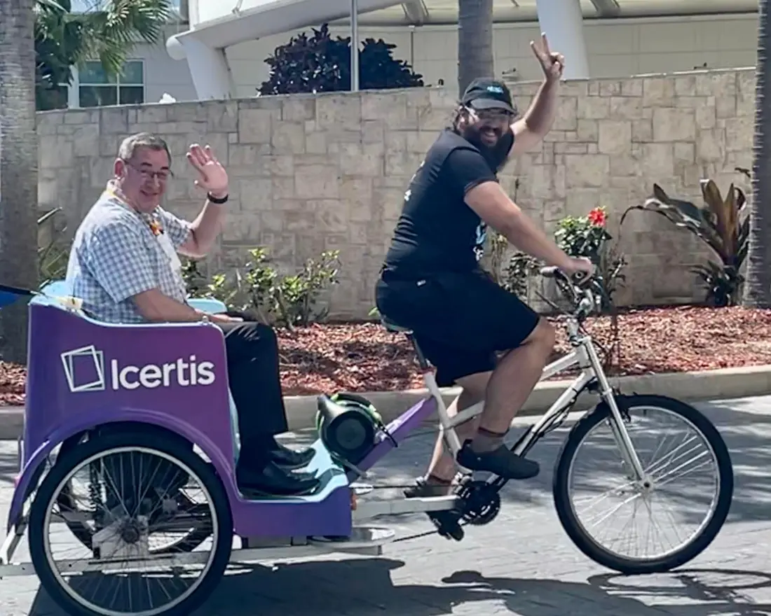 Icertis driver waving while carrying a rider