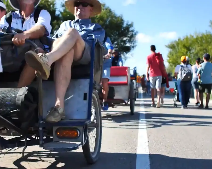 Pedicab carrying riders down a crowded event road