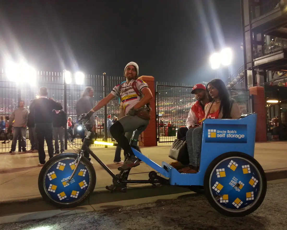 Sponsored pedicab ride outside a stadium at night